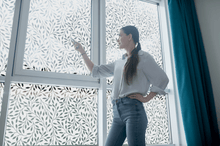 Load image into Gallery viewer, lifestyle image of a young lady in front of Etched inverse floral window film