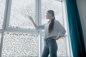 lifestyle image of a young lady in front of Etched inverse floral window film